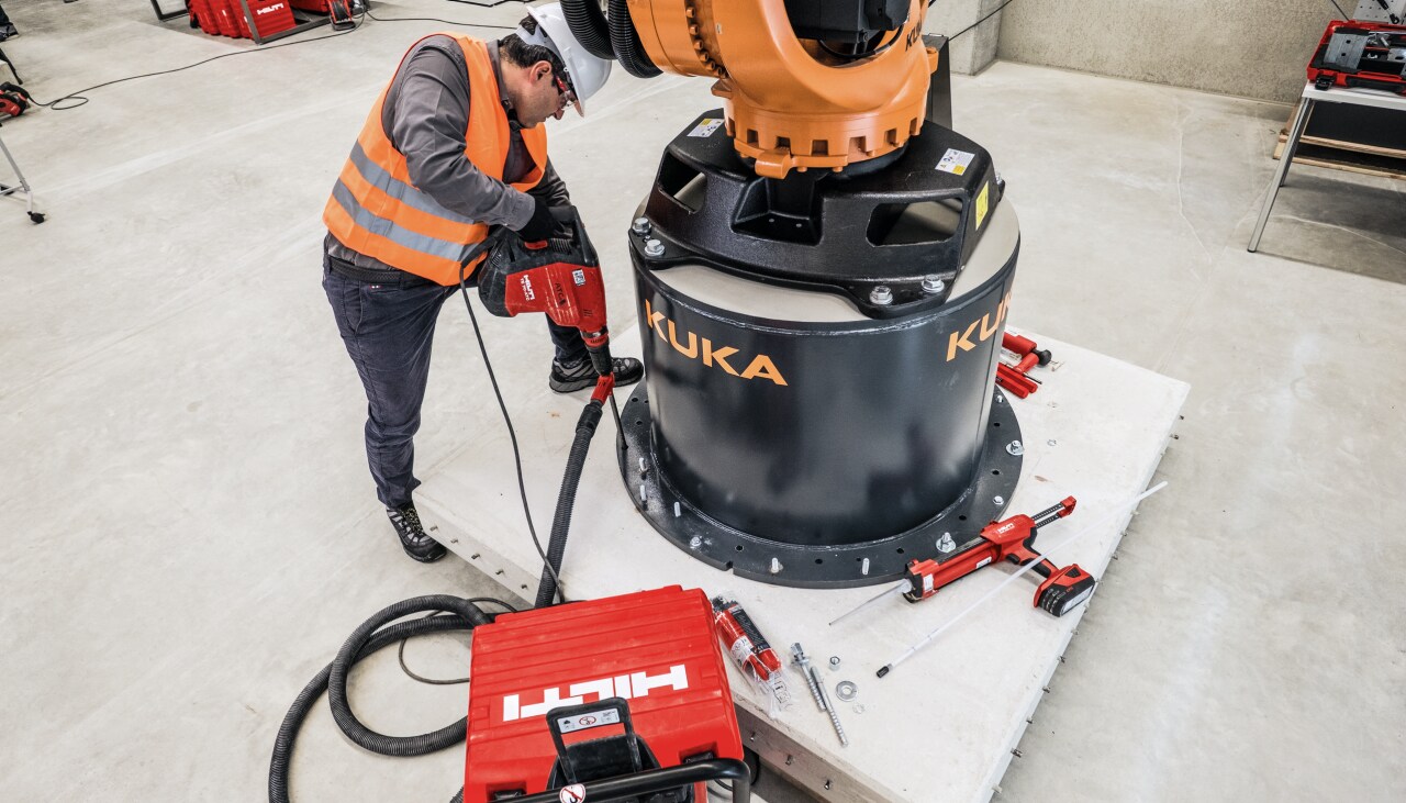 Un technicien en pleine fixation de chevilles dans le béton