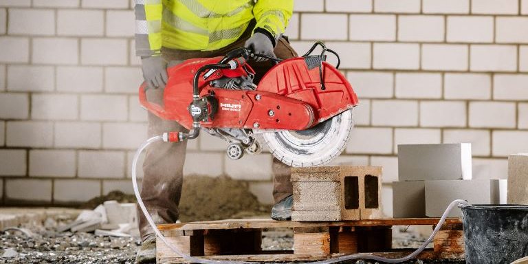 Un ouvrier utilise une scie à gaz