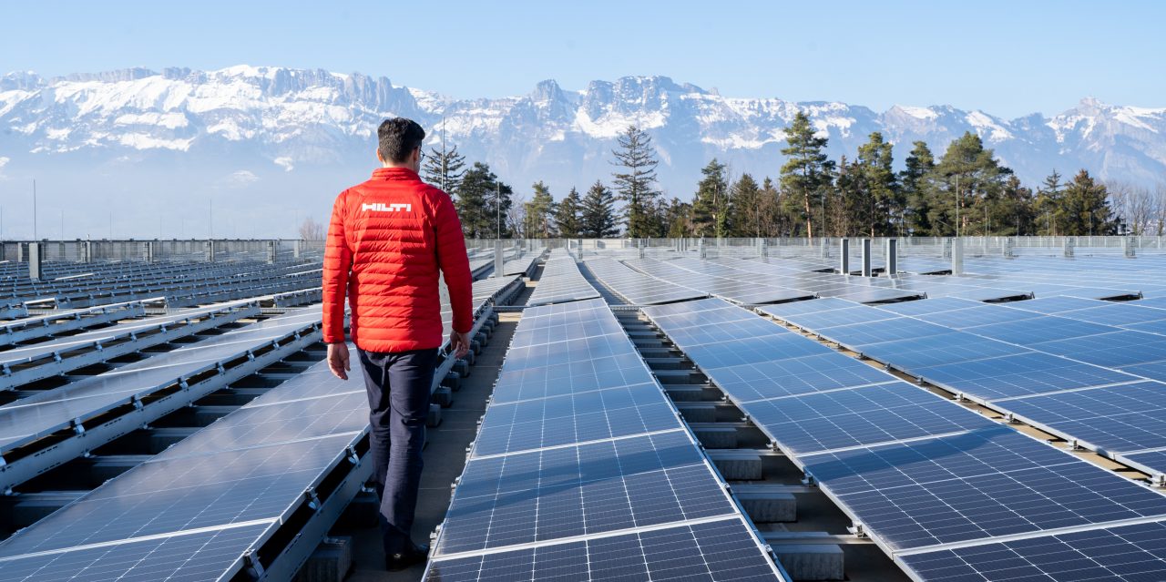 Un chargé d'affaires marche dans un champ de panneaux solaires