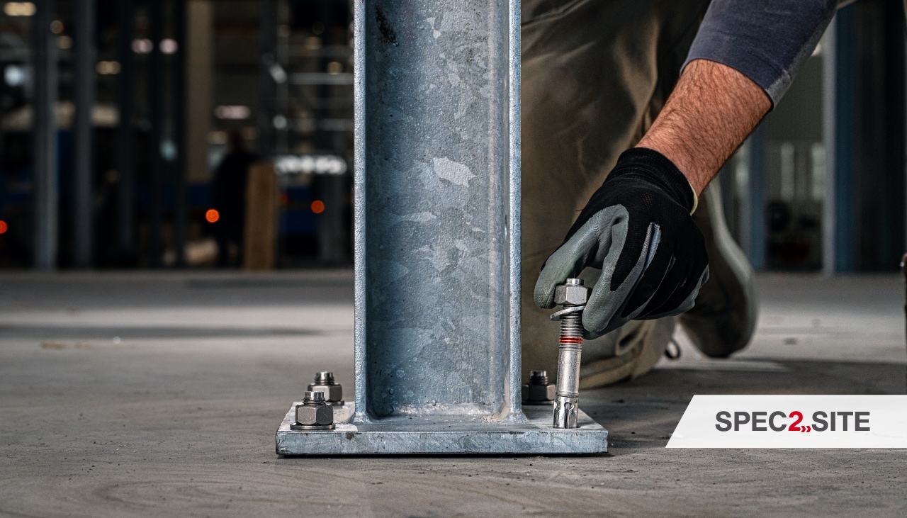 Un entrepreneur installe un ancrage dans une plaque de base.